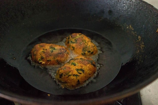 frying muthiya in hot oil in a pan