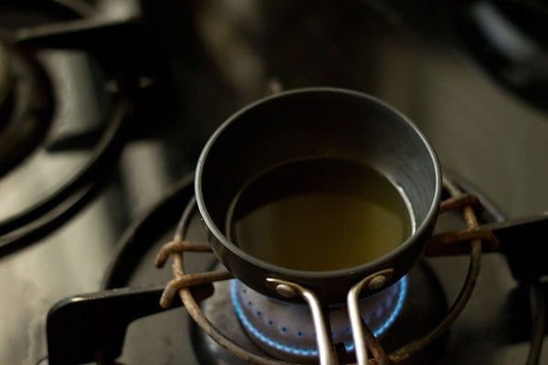 oil being heated in a small black pan