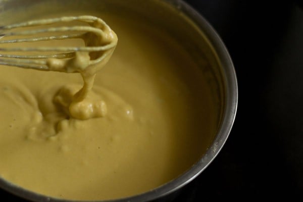 batter consistency being shown with batter falling from the wired whisk