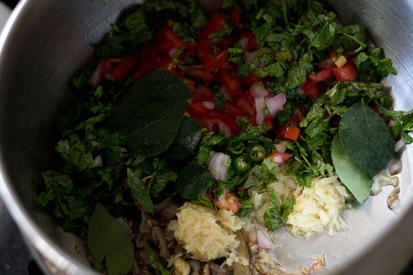 ginger-garlic paste, curry leaves, tomatoes and herbs in the pot