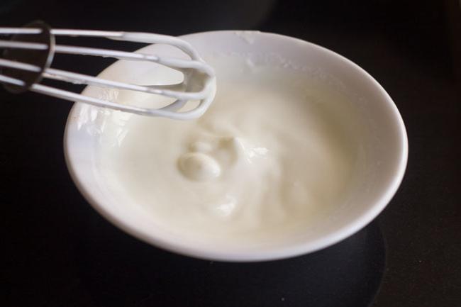 yogurt and salt whisked together in a small white bowl.
