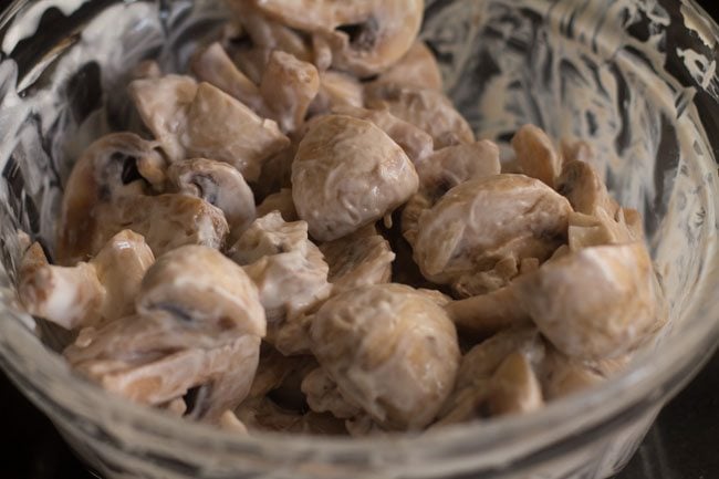 mushrooms marinating in yogurt for making methi mushroom masala