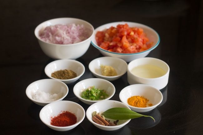 ingredients for making mushroom methi recipe all measured out into white bowls on a black table.