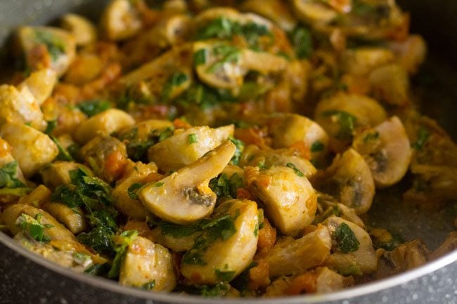 mushrooms and methi are well stirred into the masala.