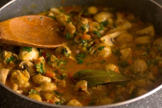 stirring mushroom methi recipe to check water level.