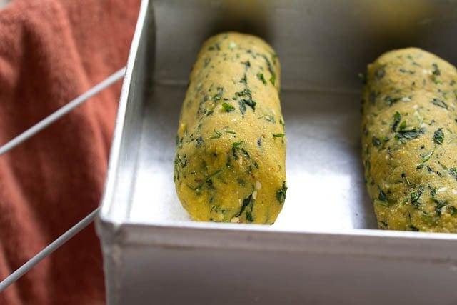 shaping methi muthiya dough in sausage type roll and placing on greased tray