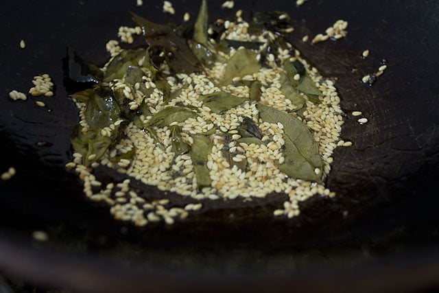 preparing tempering for steamed muthiya in a pan