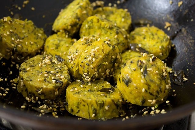 adding sliced steamed muthiya to tempering in pan and frying 