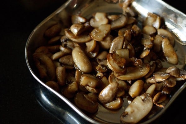 sautéed mushrooms kept aside in a square-shaped steel plate