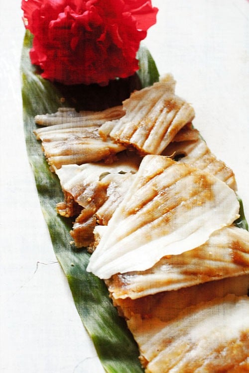 patholi served on a fresh turmeric leaf with a hibiscus flower kept on the top end. 