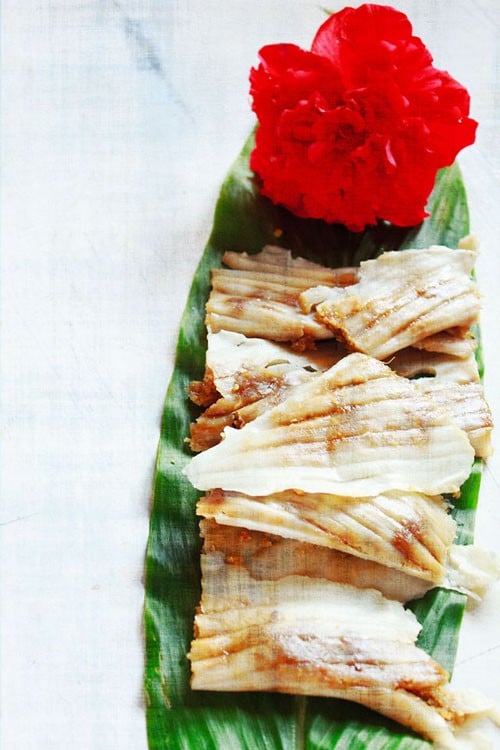 The patoli is served on fresh turmeric leaves and topped with a hibiscus flower.