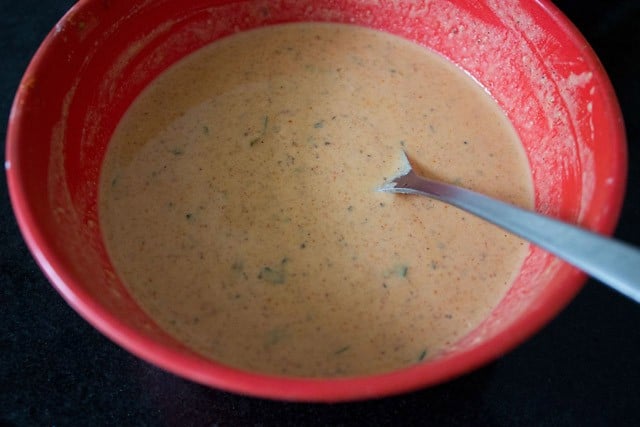 completed aloo 65 batter in a bowl with a spoon.