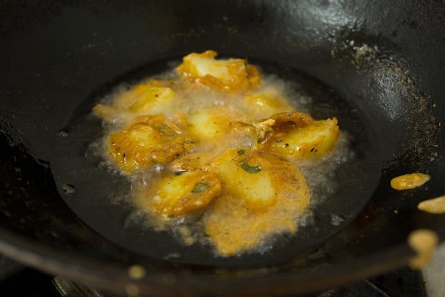 potatoes frying in a kadai.