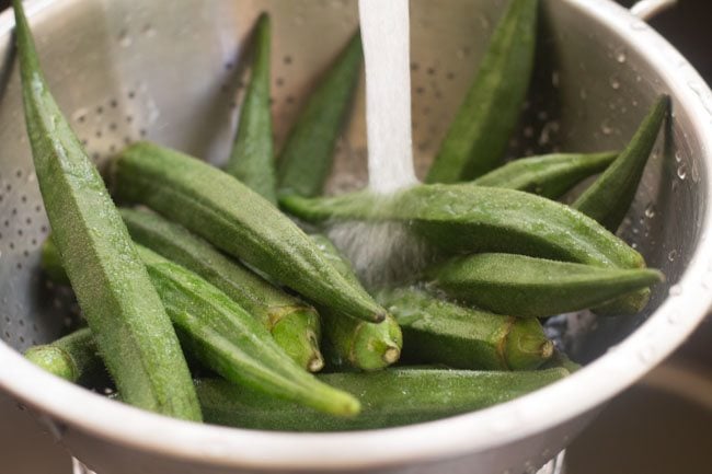 bhindi or okra being rinsed in fresh water in a colander