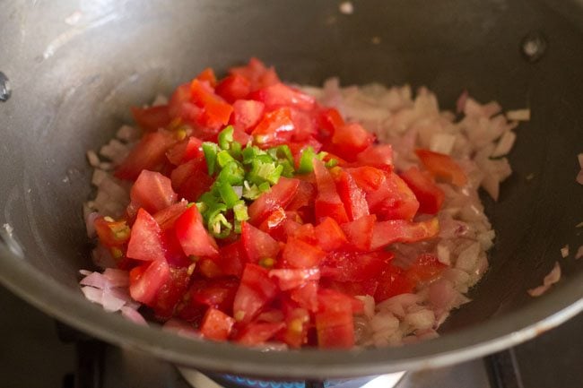 adding chopped tomatoes and green chillies