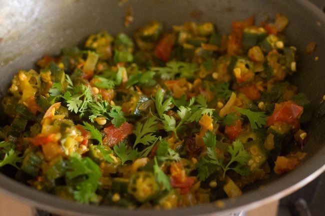 garnishing bhindi ki sabji with coriander leaves