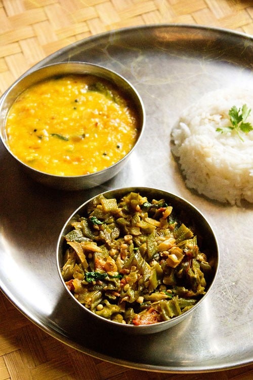 bhindi ki sabji served with dal and steamed rice in steel bowls