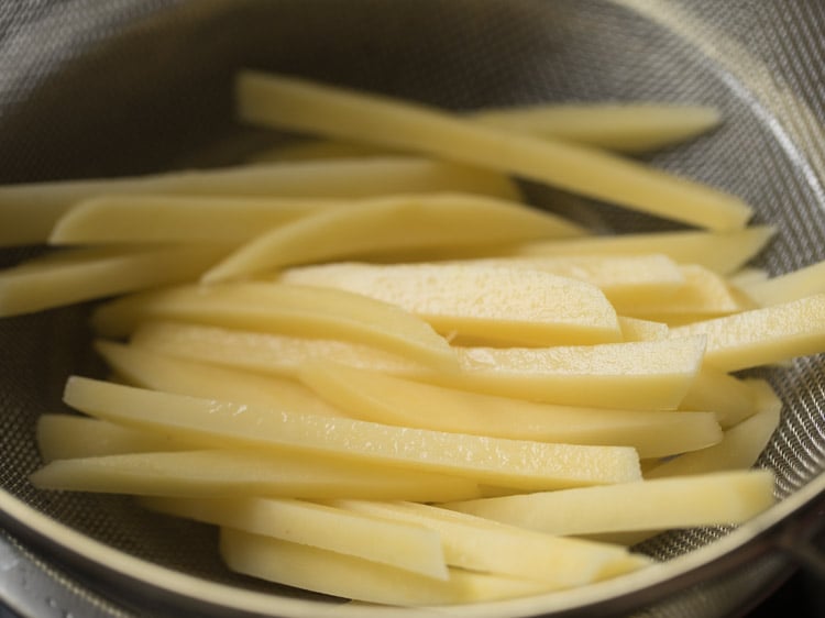 potato finger chips draining in a sieve