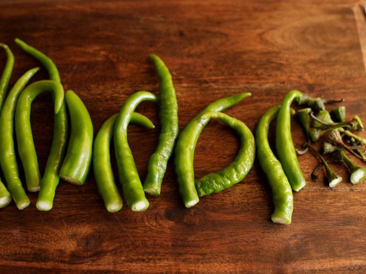 removing the crowns of the green chilies