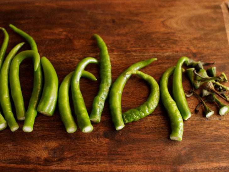 removing the crowns of the green chilies 