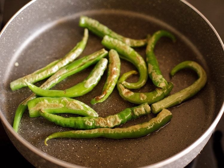 frying green chilies till lightly browned from both sides 