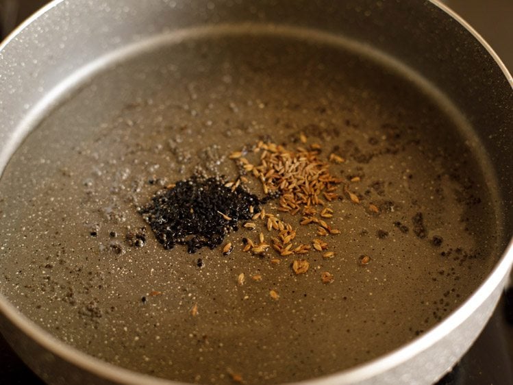 adding onion seeds and cumin seeds in the pan