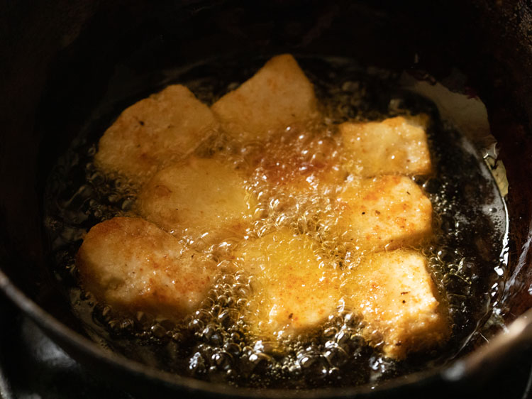 frying paneer cubes in oil in a pan