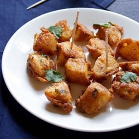 aloo 65 on a white plate garnished with mint and with a few toothpicks on them
