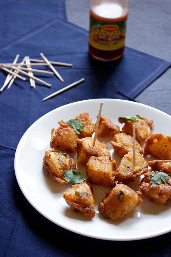 aloo 65 on a white plate garnished with mint and with a few toothpicks on them