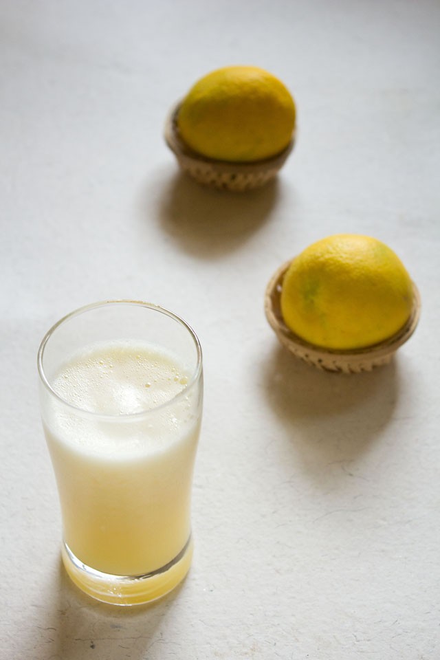 sweet lime juice recipe in a clear glass with a halved mosambi in the background.
