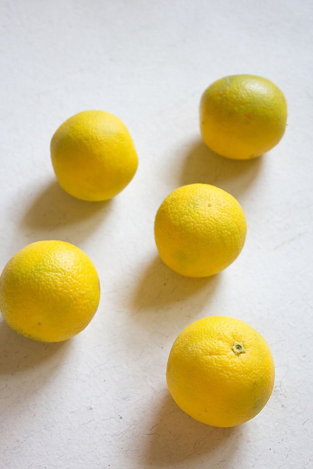 sweet limes on a white table - they are more yellow than green, and look like very round lemons.