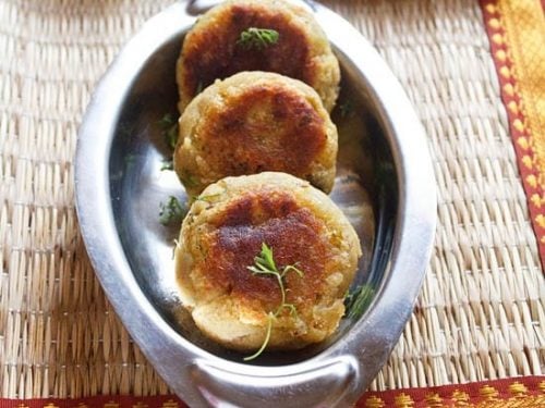 sweet potato cutlet garnished with coriander leaves and served in a steel platter.