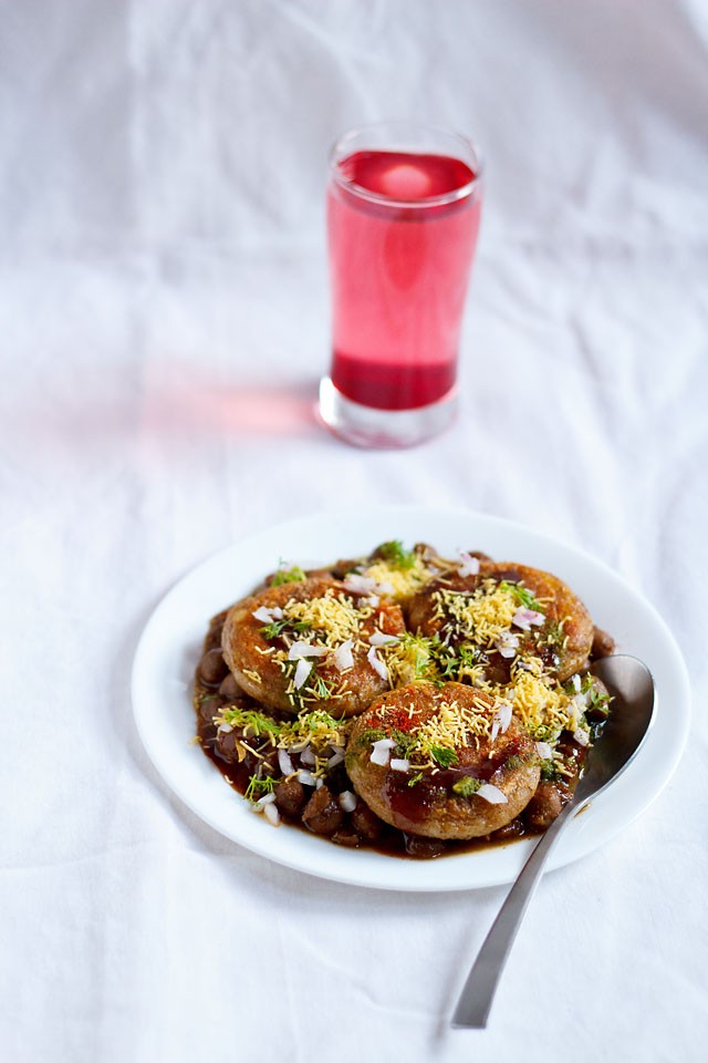 aloo tikki chole served in a white plate with spoon