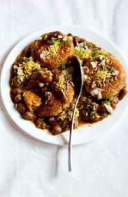 aloo tikki chole served on white plate with a spoon in the center