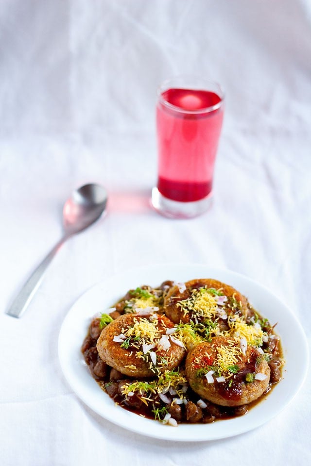 aloo tikki chole served in a white plate with spoon