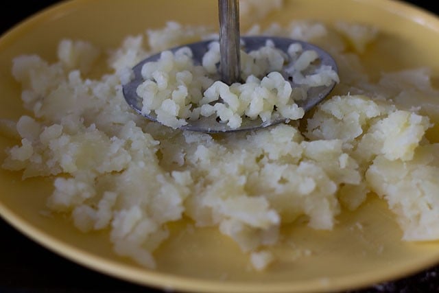 mashing boiled potatoes on plate