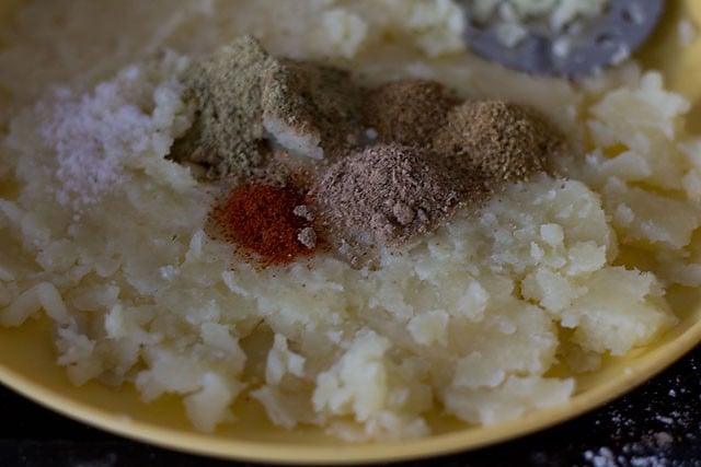 adding spices and salt to mashed potatoes on plate