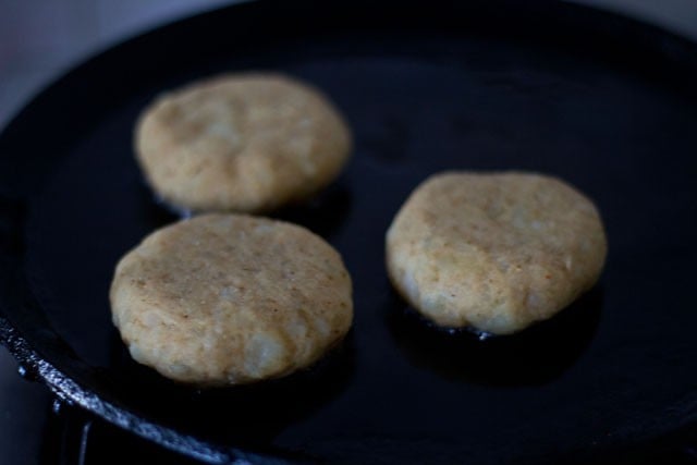 prepared tikkis placed in hot oil on frying pan