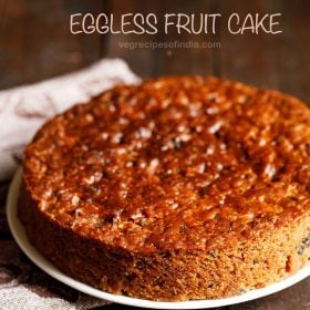 eggless fruit cake placed on a white plate with a printed napkin at the side