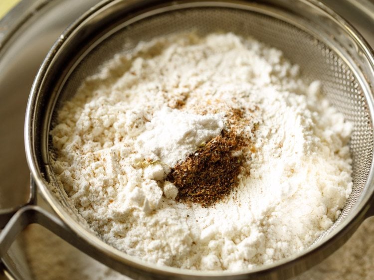 baking powder and ground spice mix added to the flours in the sieve.