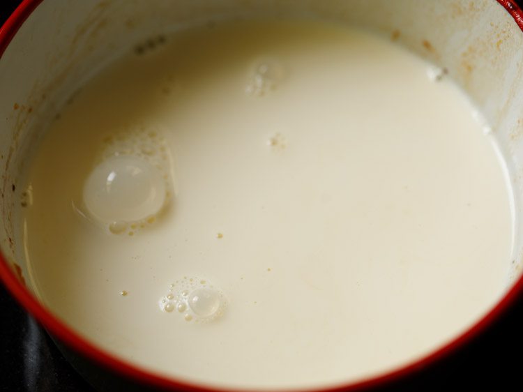 soy milk added in a bowl with the red rim.