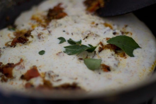 adding cashewnut-coconut paste and curry leaves to the masala 