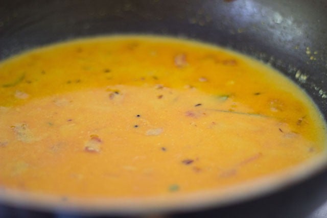 adding the green peas stock or water to the masala 