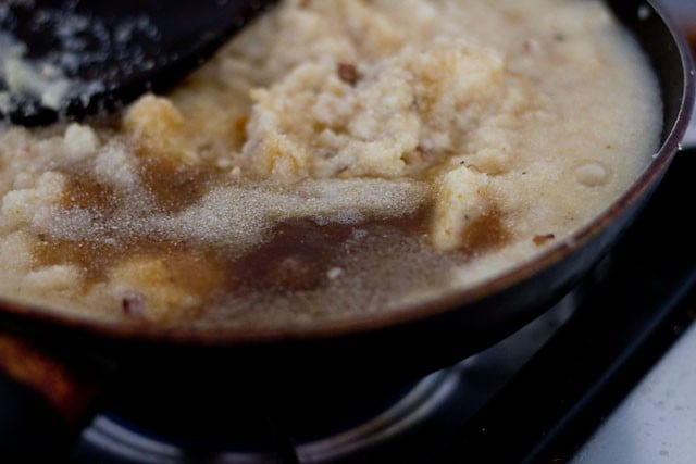 adding sugar to semolina in pan.