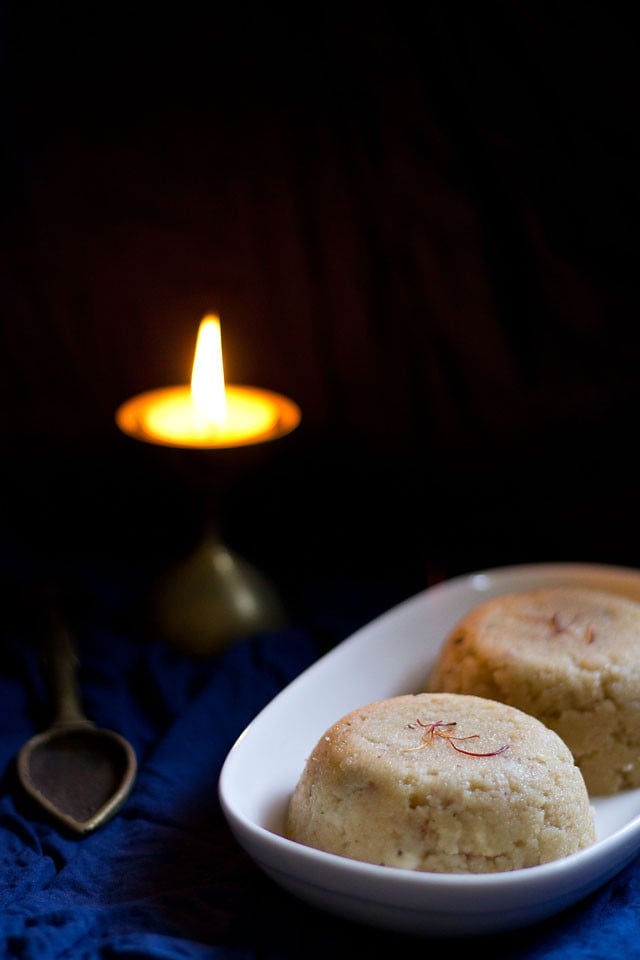 banana halwa served on a platter with a lit lamp in the background.