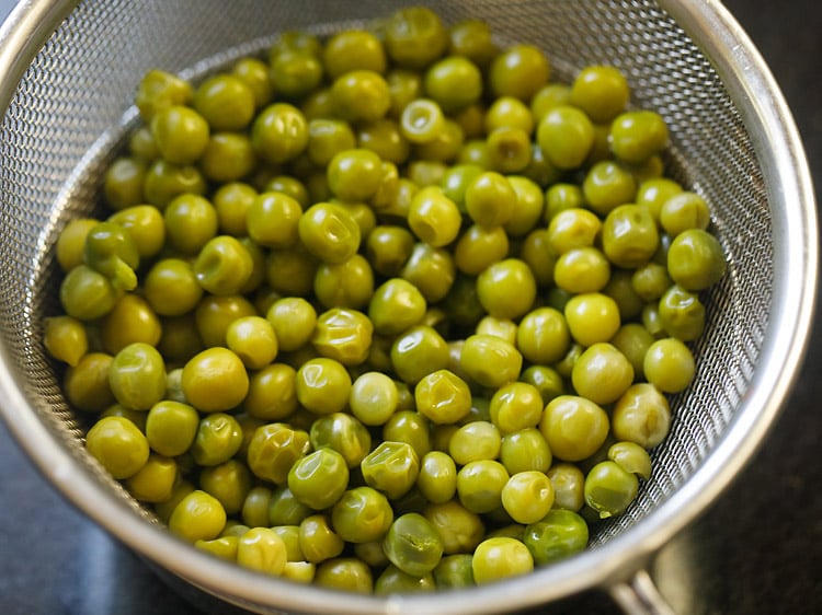 cooked peas in a strainer