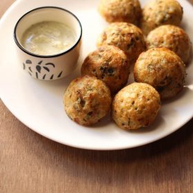 paniyaram recipe served in a white plate with coconut chutney in a bowl