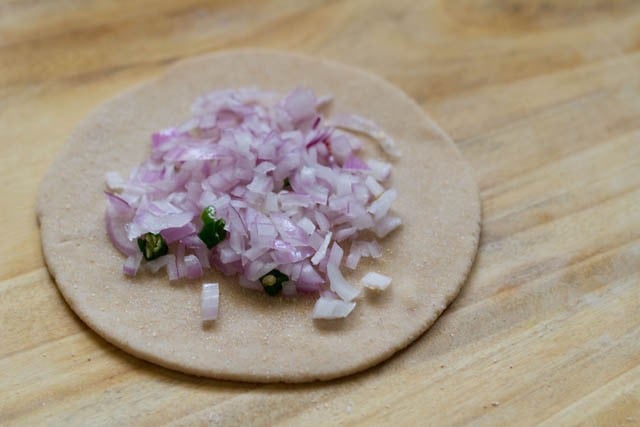 onions and green chillies topped on the rolled dough