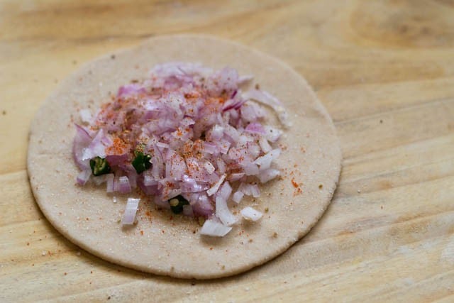 ground spices and salt sprinkled on the onion layer