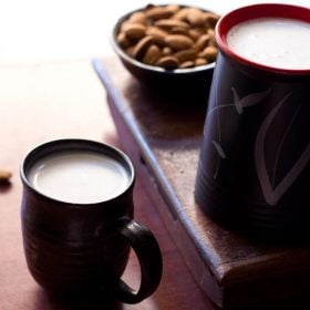 almond milk in a black ceramic jar and small mug.